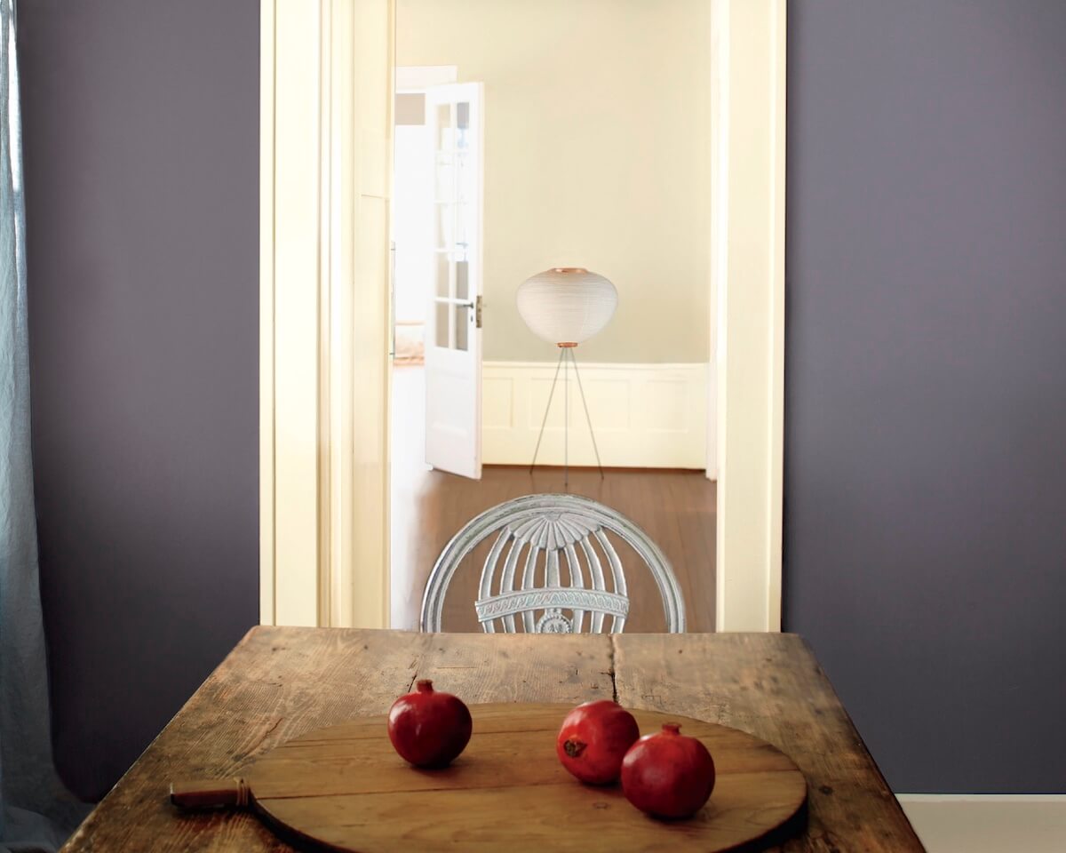 Rustic plank table with grey-blue wall and pomegranates